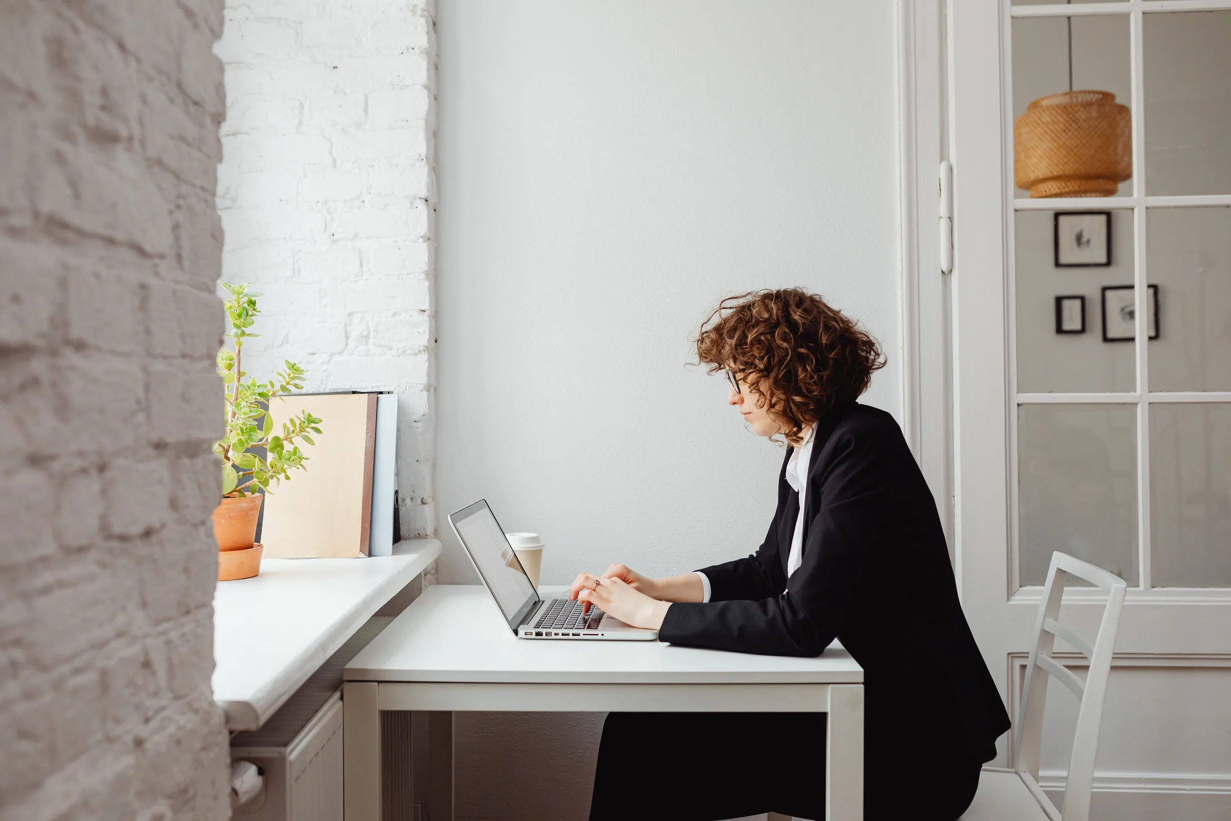 A professional woman working on her laptop in a modern workspace